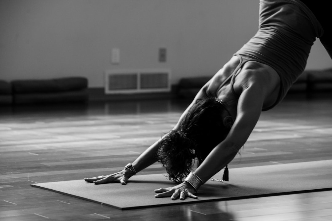 woman-in-black-tank-top-and-black-pants-bending-her-body-on-floor-uxkcszrwm2s